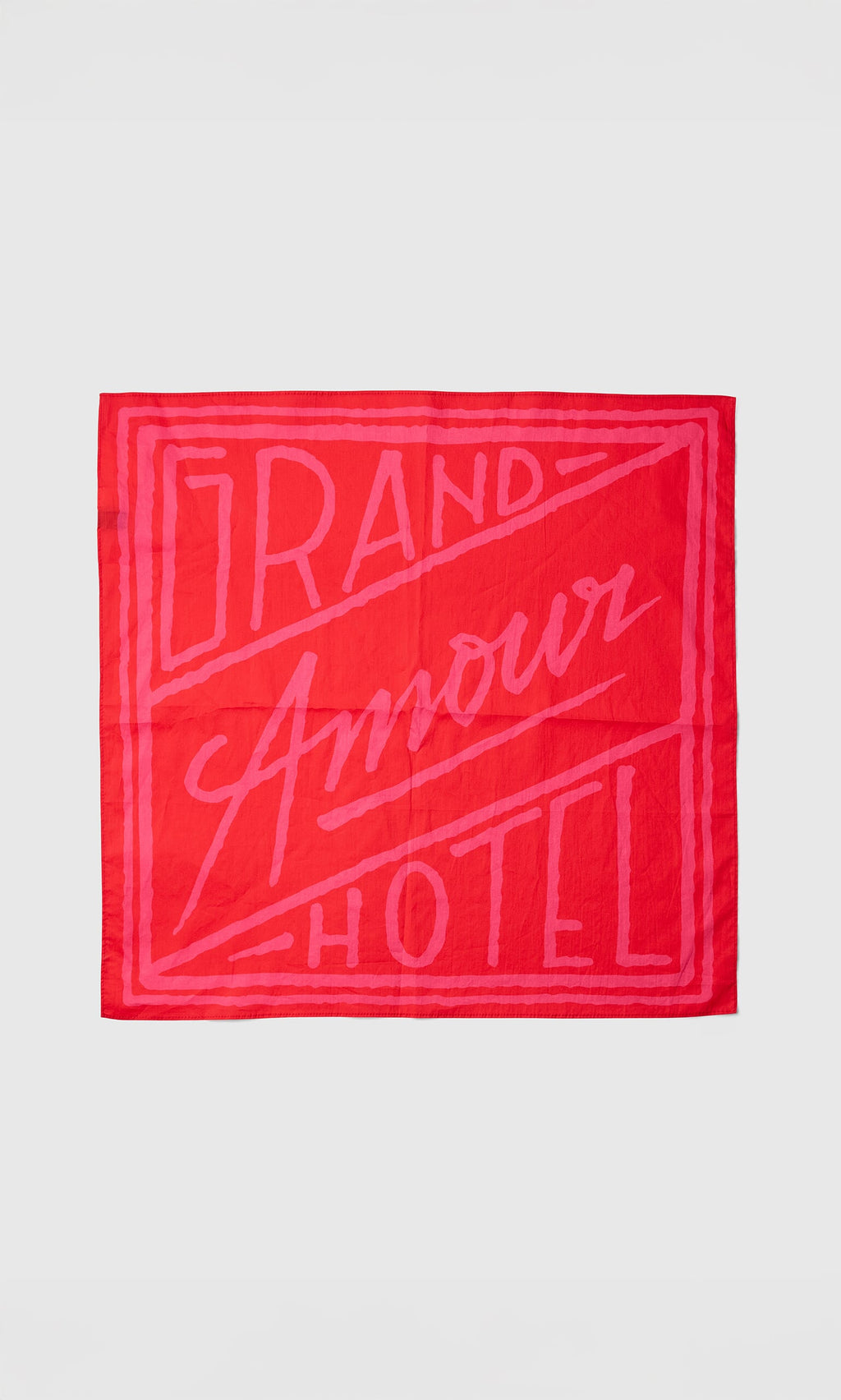 Plümo- The Poinsettia Necktie is red and pink with "Grand Amour Hotel" in bold, stylized letters.