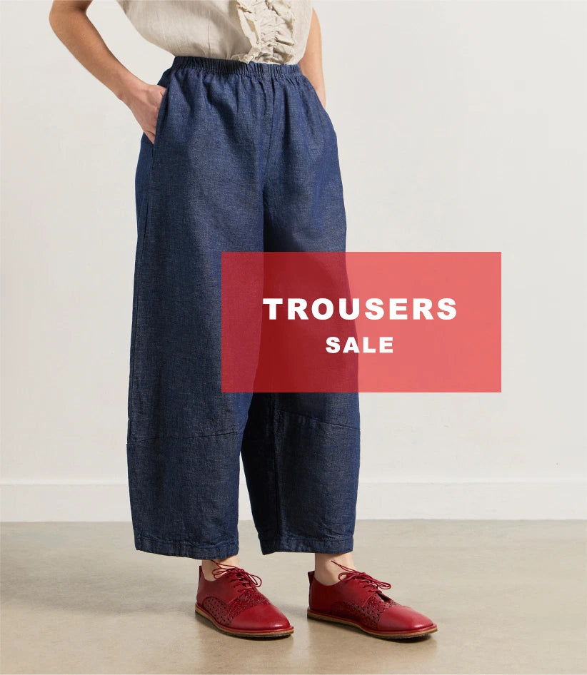 Plümo  Person wearing wide-leg blue trousers and red shoes; Trousers Sale text on a red box over the image.