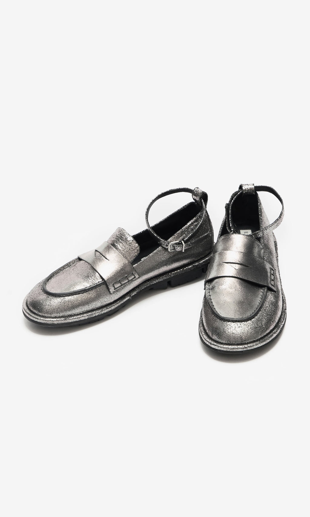 Plümo- Silver Loafers with detachable ankle straps, one upright and one leaning on a white background.