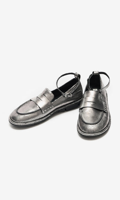 Plümo- Silver Loafers with detachable ankle straps, one upright and one leaning on a white background.