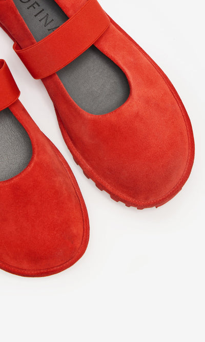 Plümo- Close-up of Sola Red Flats, scarlet suede Mary Jane shoes with a single strap, on a white background.