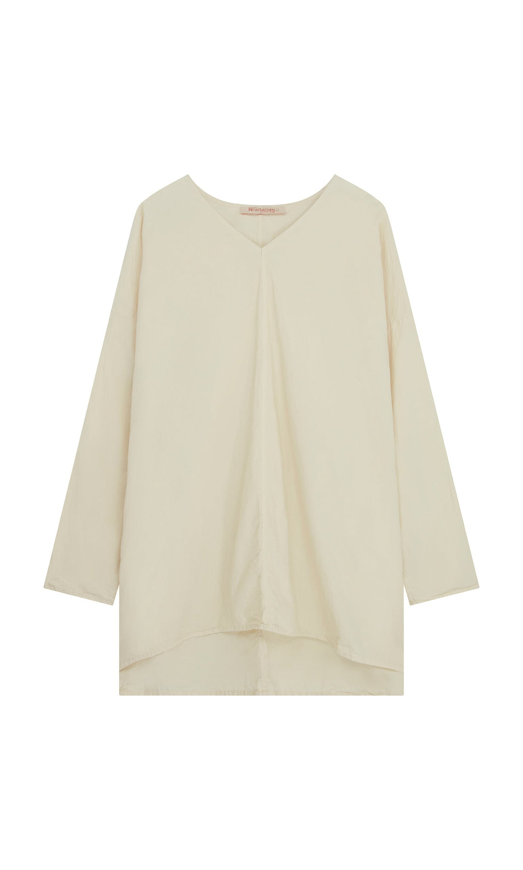 Plümo- Stroh Blouse: cream cotton poplin, V-neck, long sleeves, loose fit, slightly asymmetric hemline.