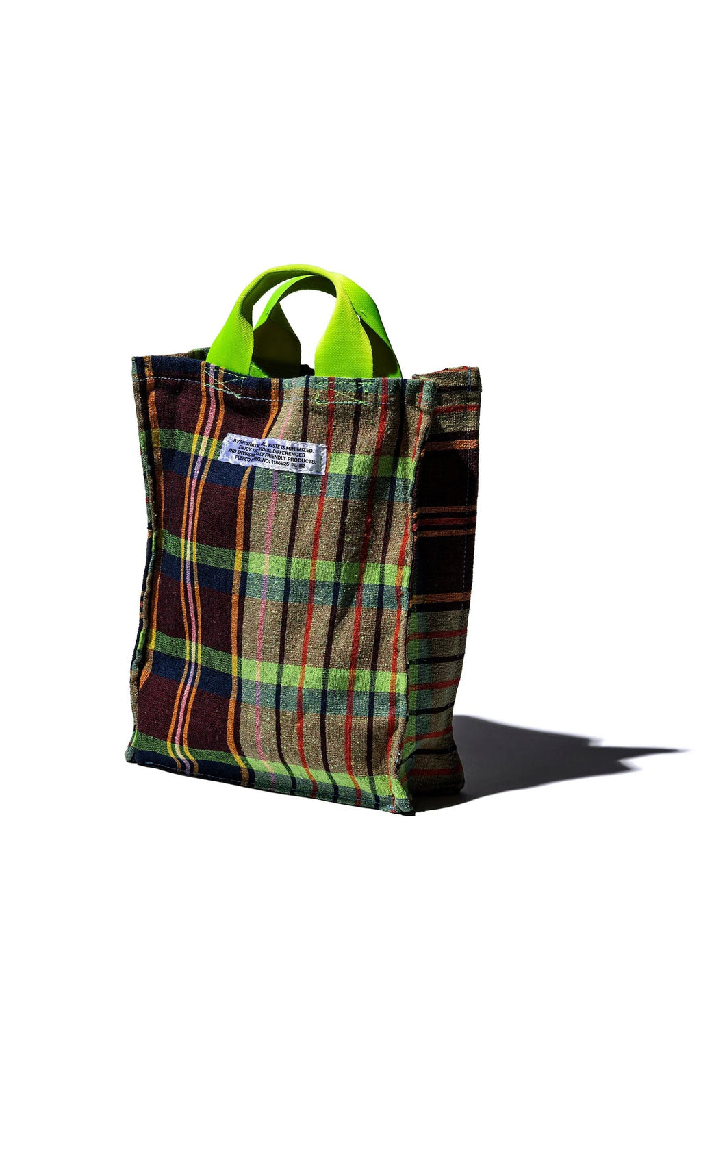 Plümo- Tartan Document Holder made from recycled checkered fabric with green handles and label, casting shadow on white.