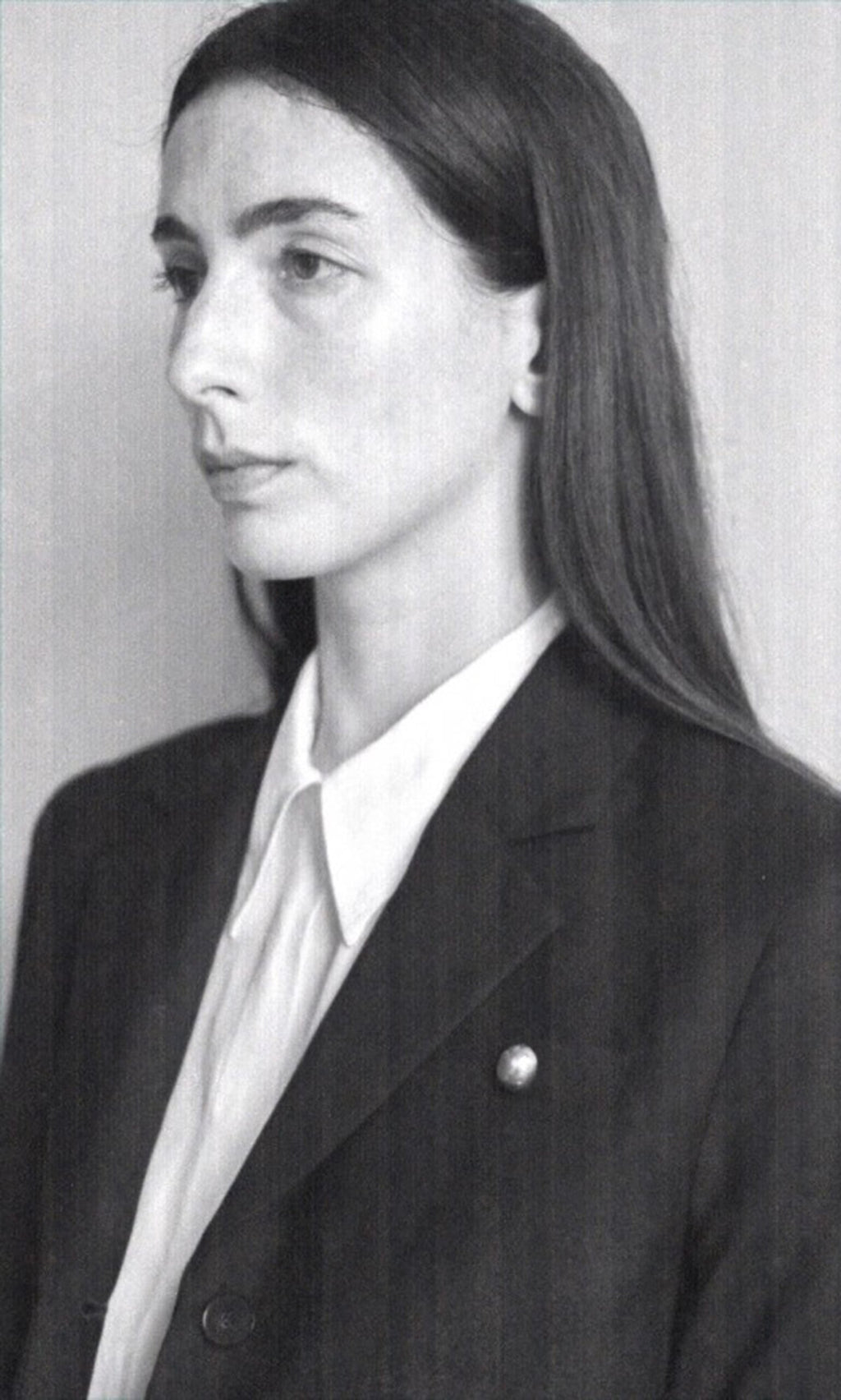 Plümo- Black and white portrait of a woman in a blazer and white shirt, wearing the handmade Amara Brooch.