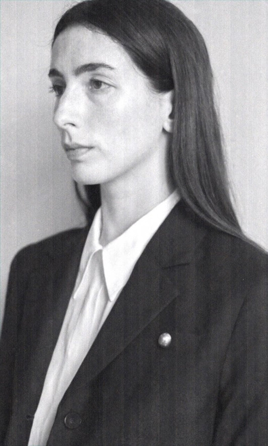 Plümo- Black and white portrait of a woman in a blazer and white shirt, wearing the handmade Amara Brooch.