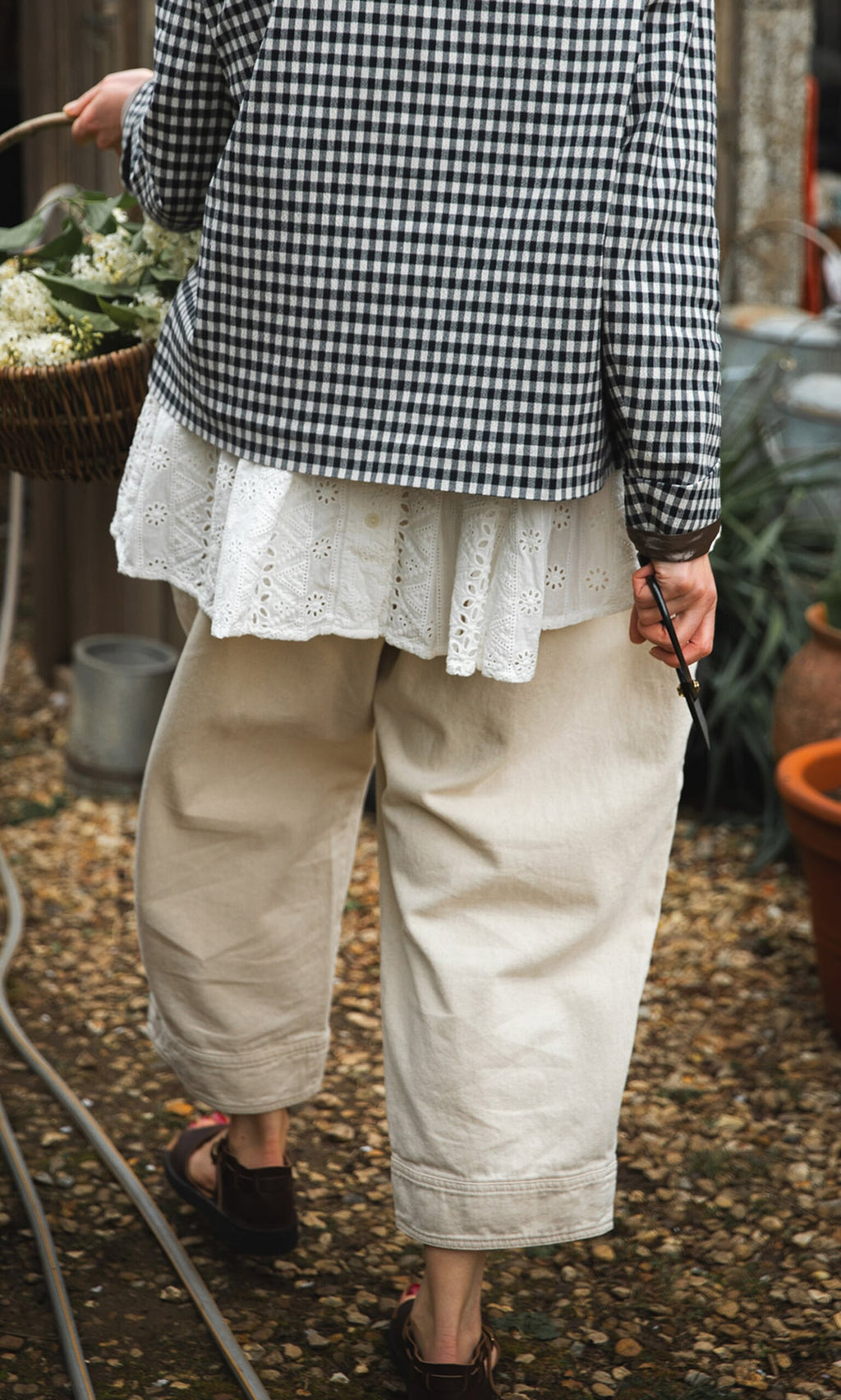 Plümo- Person in a checkered shirt holds Higurashi scissors and a basket outdoors on a gravel path.