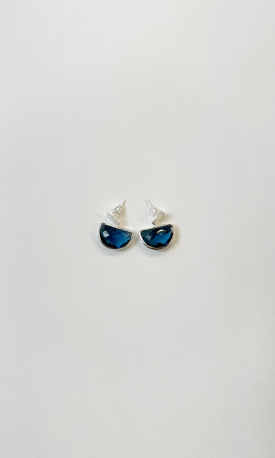 Plümo- Ianthe Studs: Modern earrings with semicircular blue gemstones and sleek silver finish on a white background.