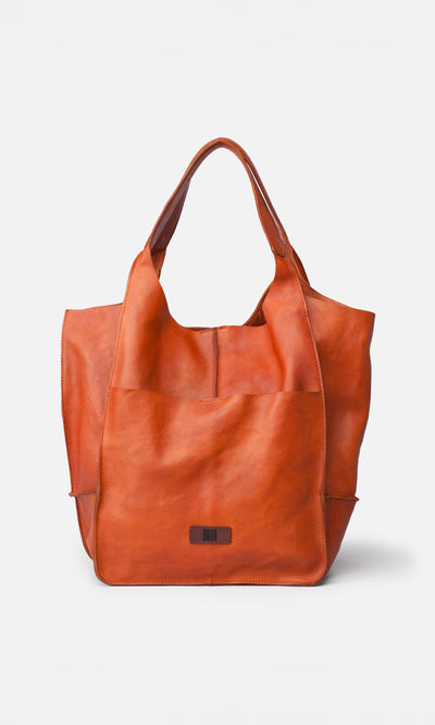 Plümo- Miller Tote: spacious orange-brown washed leather bag with wide handles and front pocket, pictured on white background.
