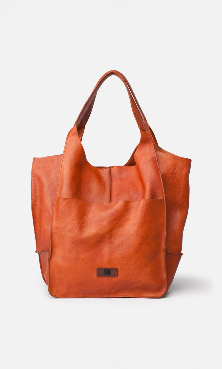 Plümo- Miller Tote: spacious orange-brown washed leather bag with wide handles and front pocket, pictured on white background.