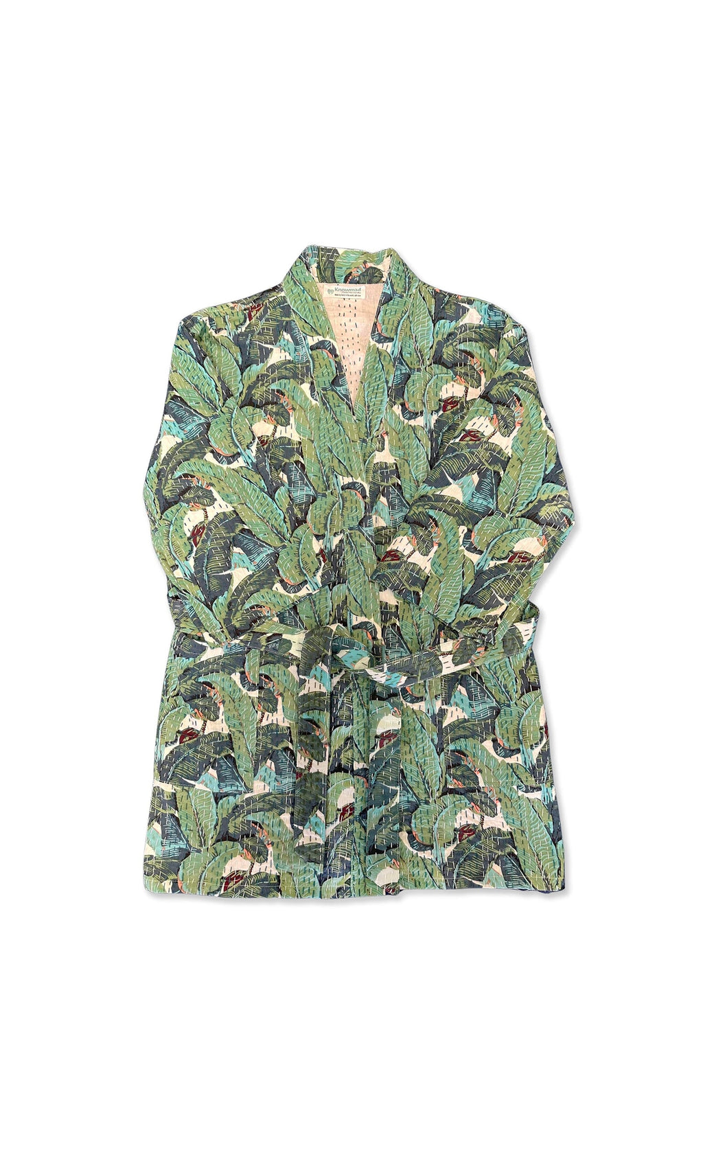 Plümo- The Musa Quilted Kantha is a folded kimono jacket with a green jungle leaf print and matching belt on white background.