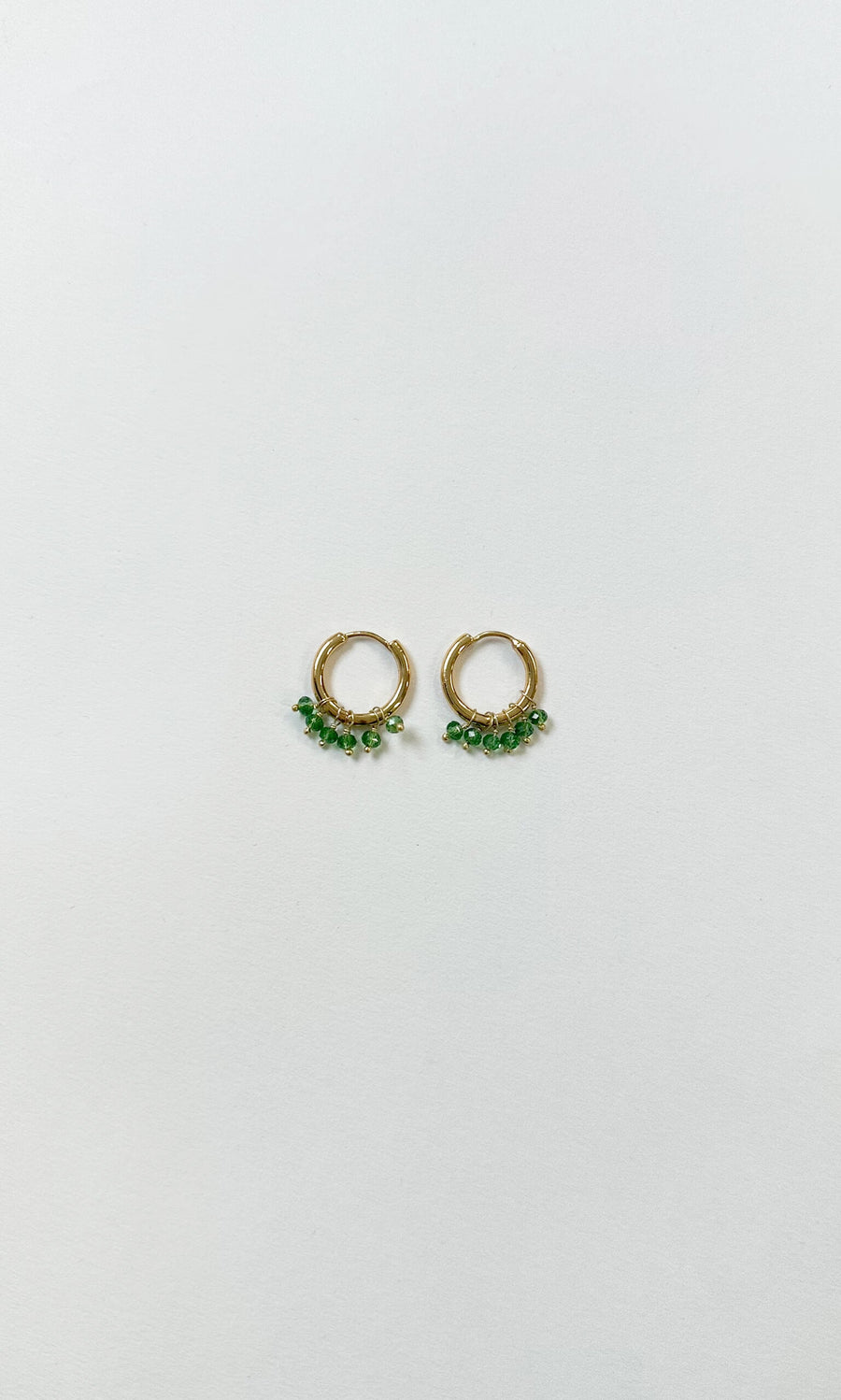 Plümo- Aurelie Crystal Hoops: gold click-closure earrings with small green crystal beads, shown on a white background.