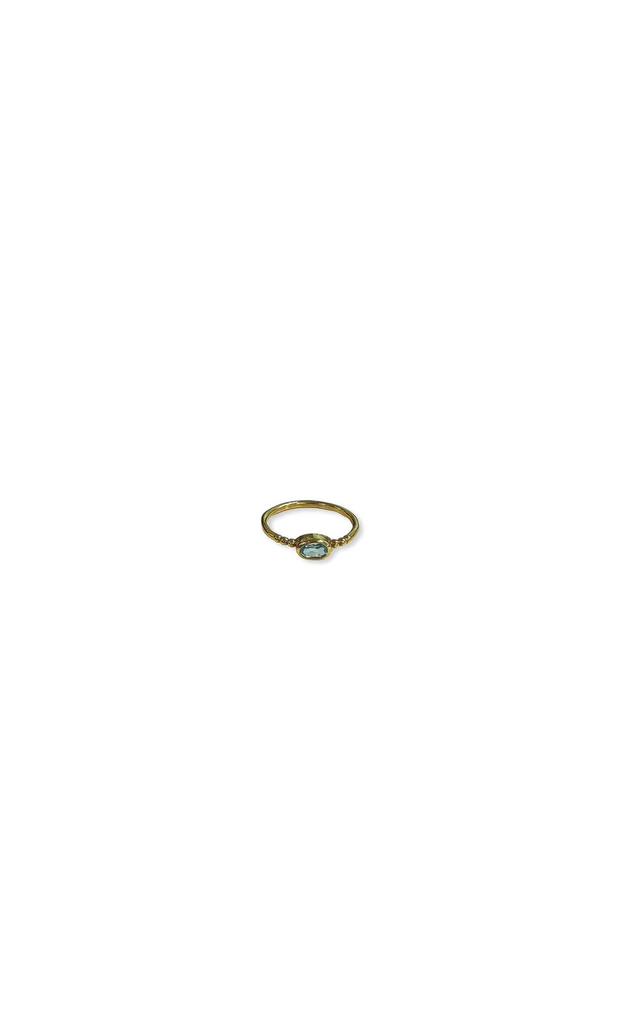Plümo- A minimalist gold-plated Blue Topaz Ring with a small oval gemstone, displayed on a white background.