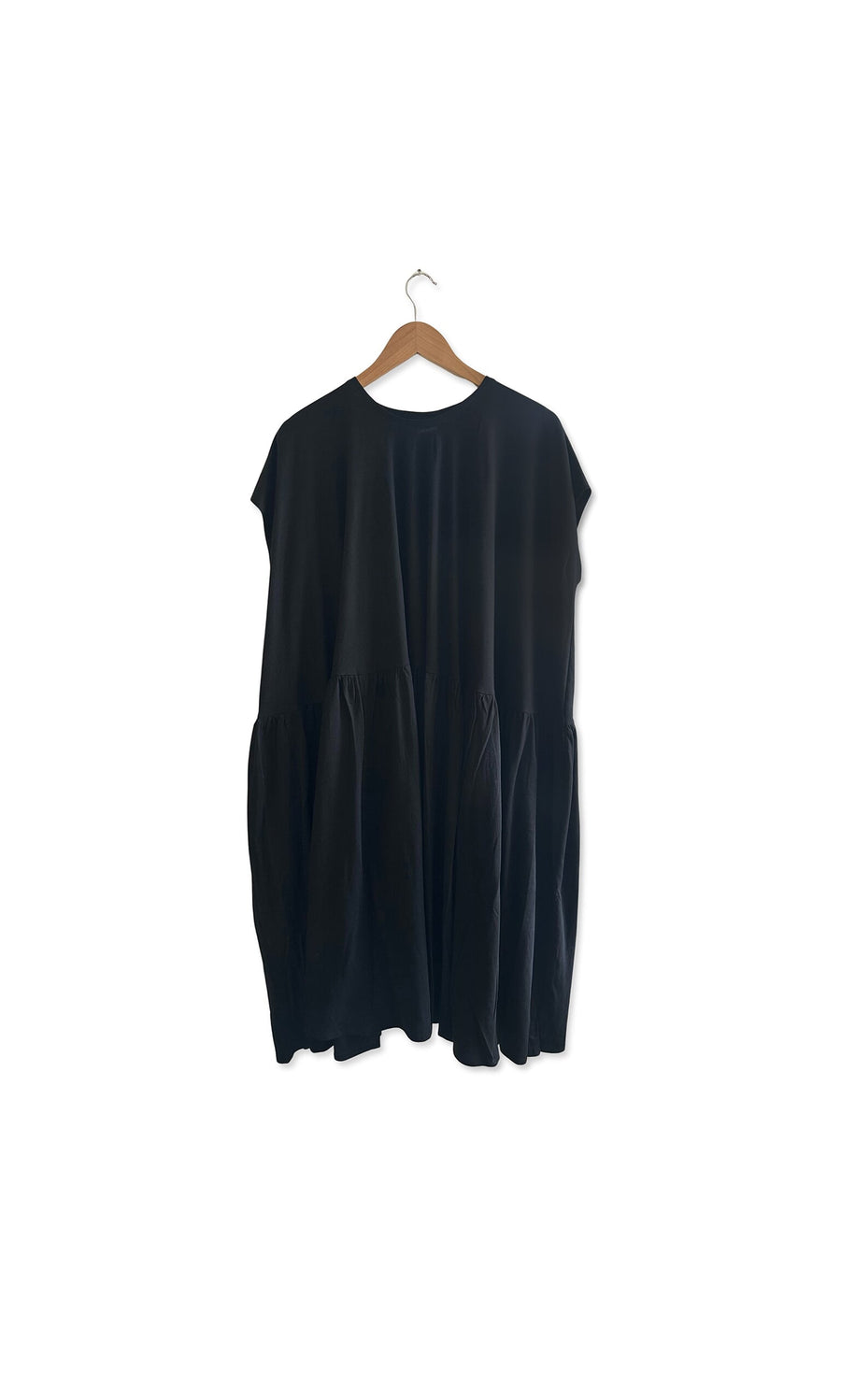Plümo- Echo Dress in black cotton jersey with short sleeves and relaxed fit, displayed on a wooden hanger.