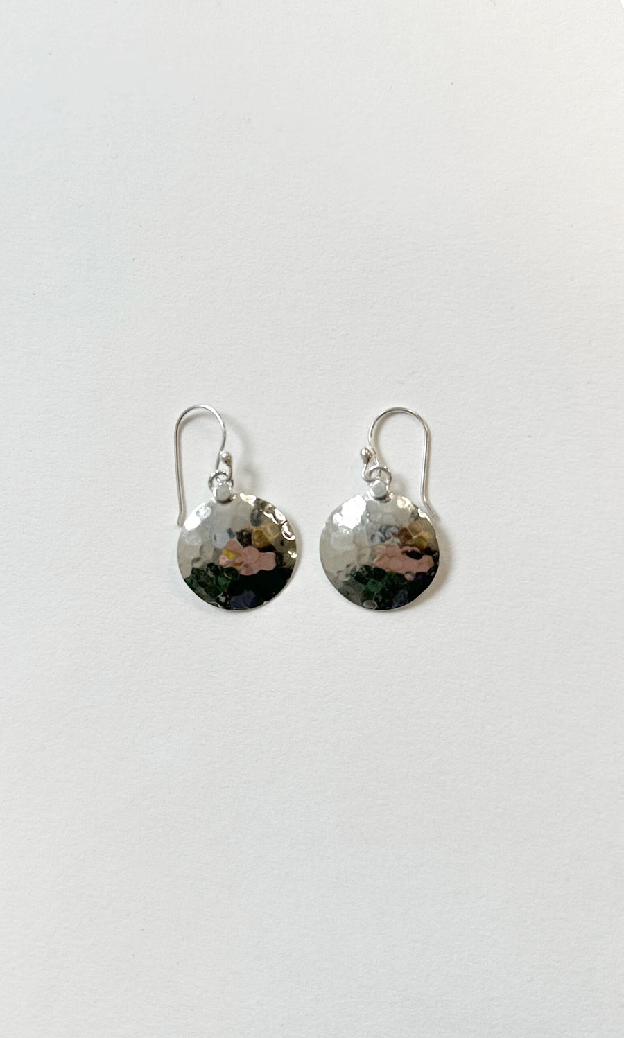 Plümo- Hammered Earrings: round silver disc with hook clasps, displayed on a plain white background.