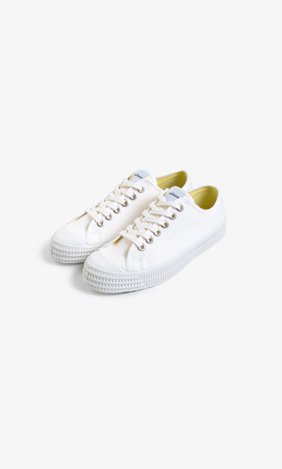 Plümo- The Novesta Canvas Trainer - Photoshoot Sample: white low tops with white laces and rubber soles on a plain background.