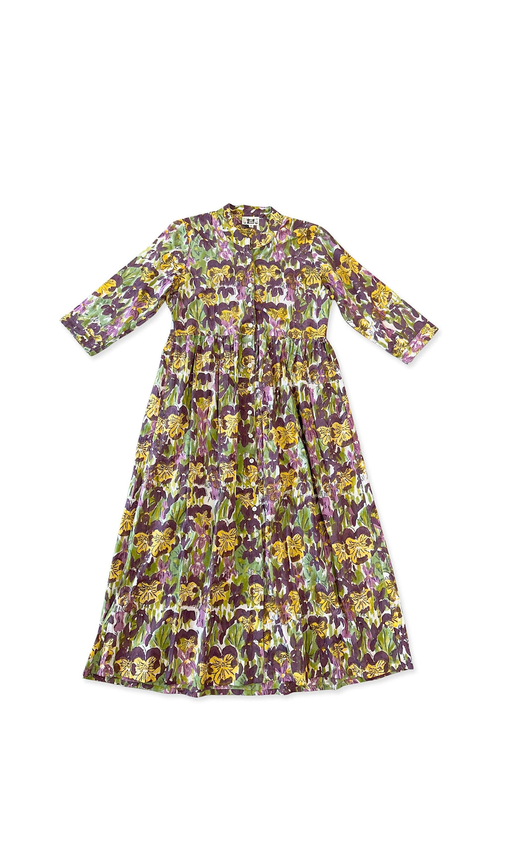 Plümo- The Pansy Dress is a long, relaxed cotton dress with block-printed floral patterns in purple, yellow, and green.