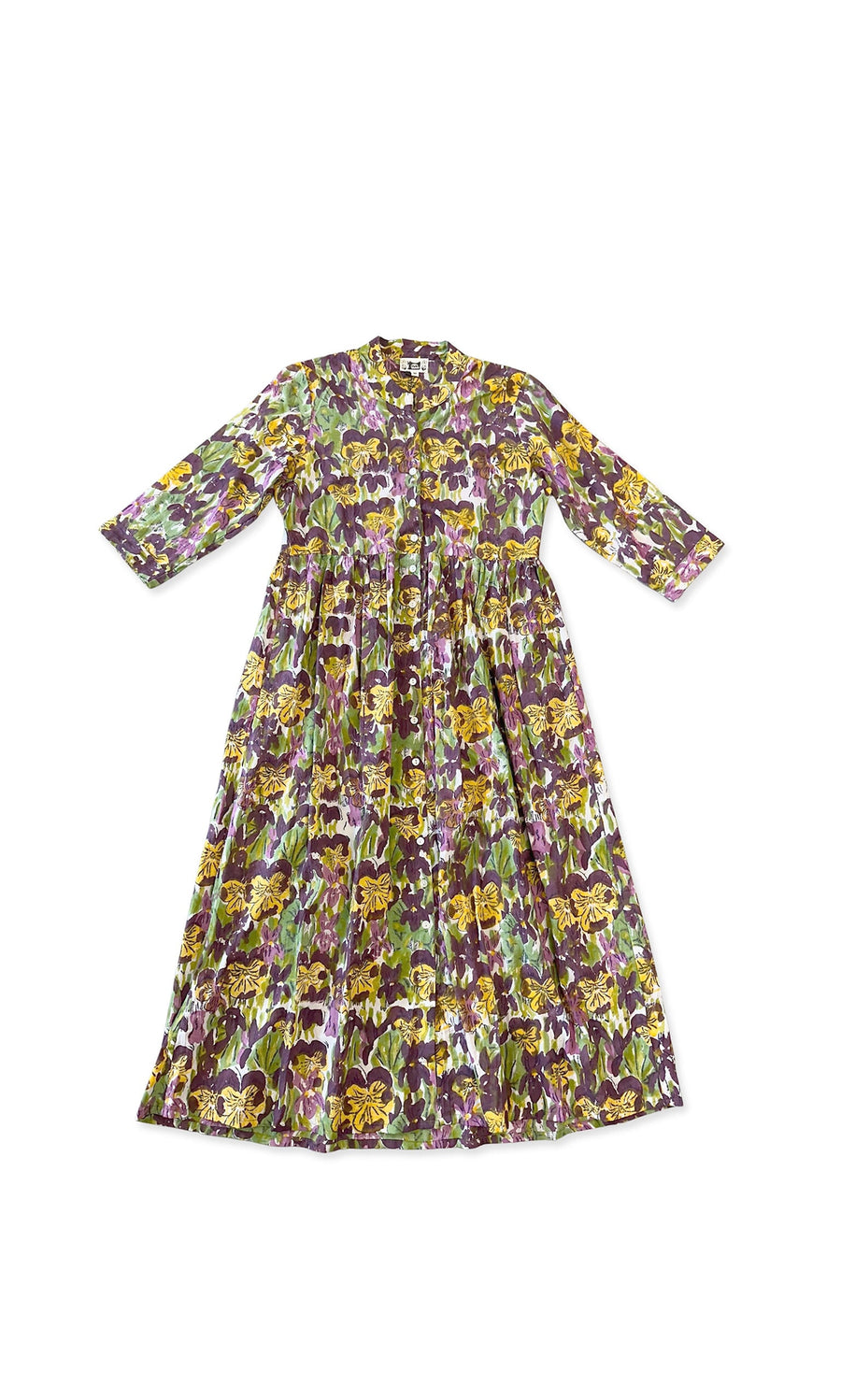 Plümo- The Pansy Dress is a long, relaxed cotton dress with block-printed floral patterns in purple, yellow, and green.