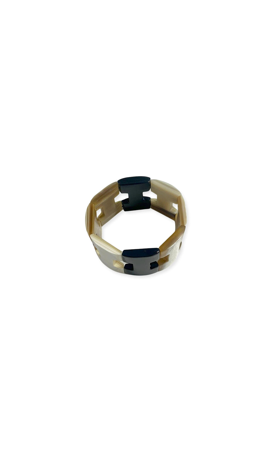 Plümo- The Sariel Bracelet: a beige plastic ring with four black clips, shown on a white background.