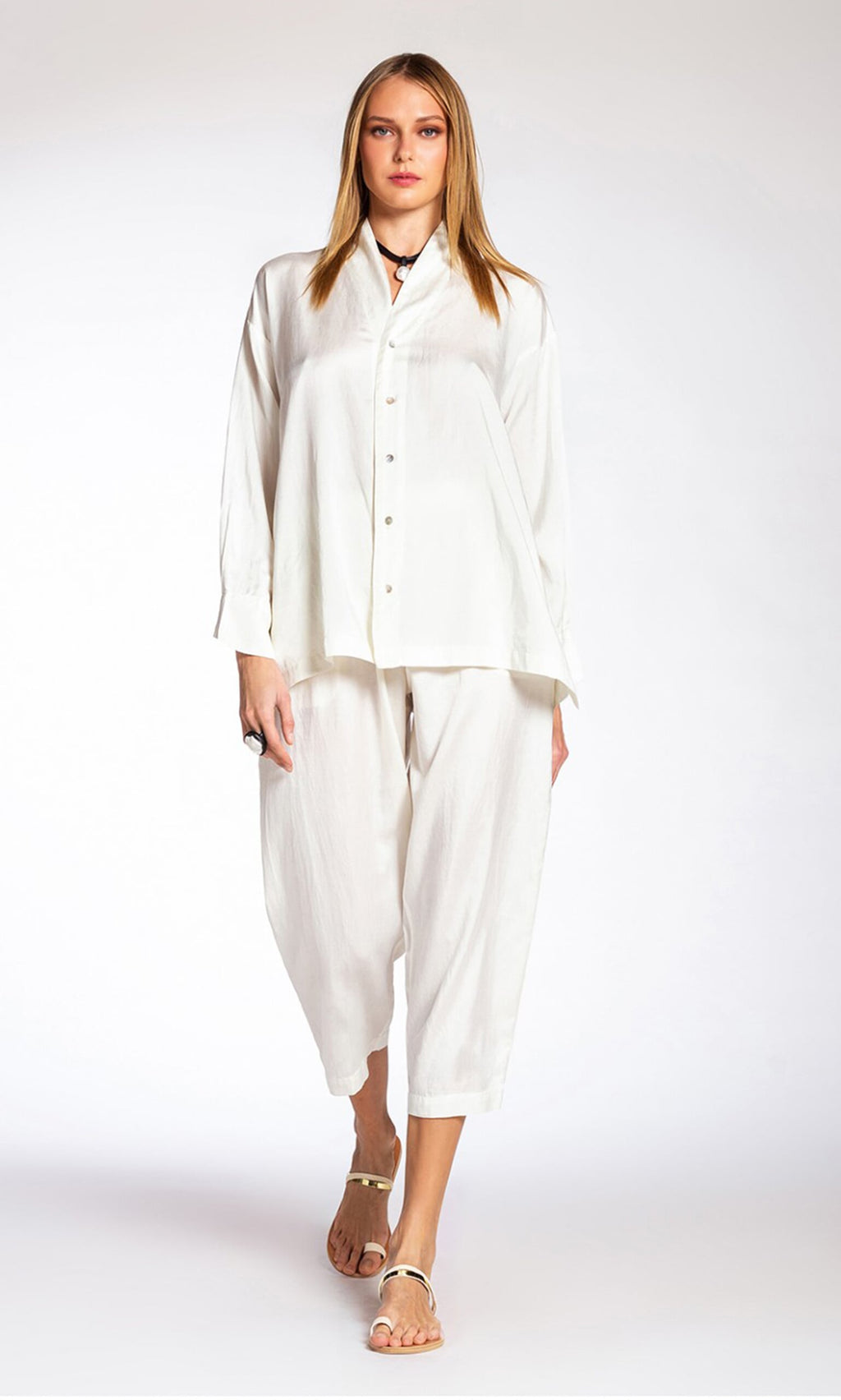 Plümo- Woman in Serina Silk Pants, white silk-cotton with elastic drawstring waist, paired with a loose white button-up.