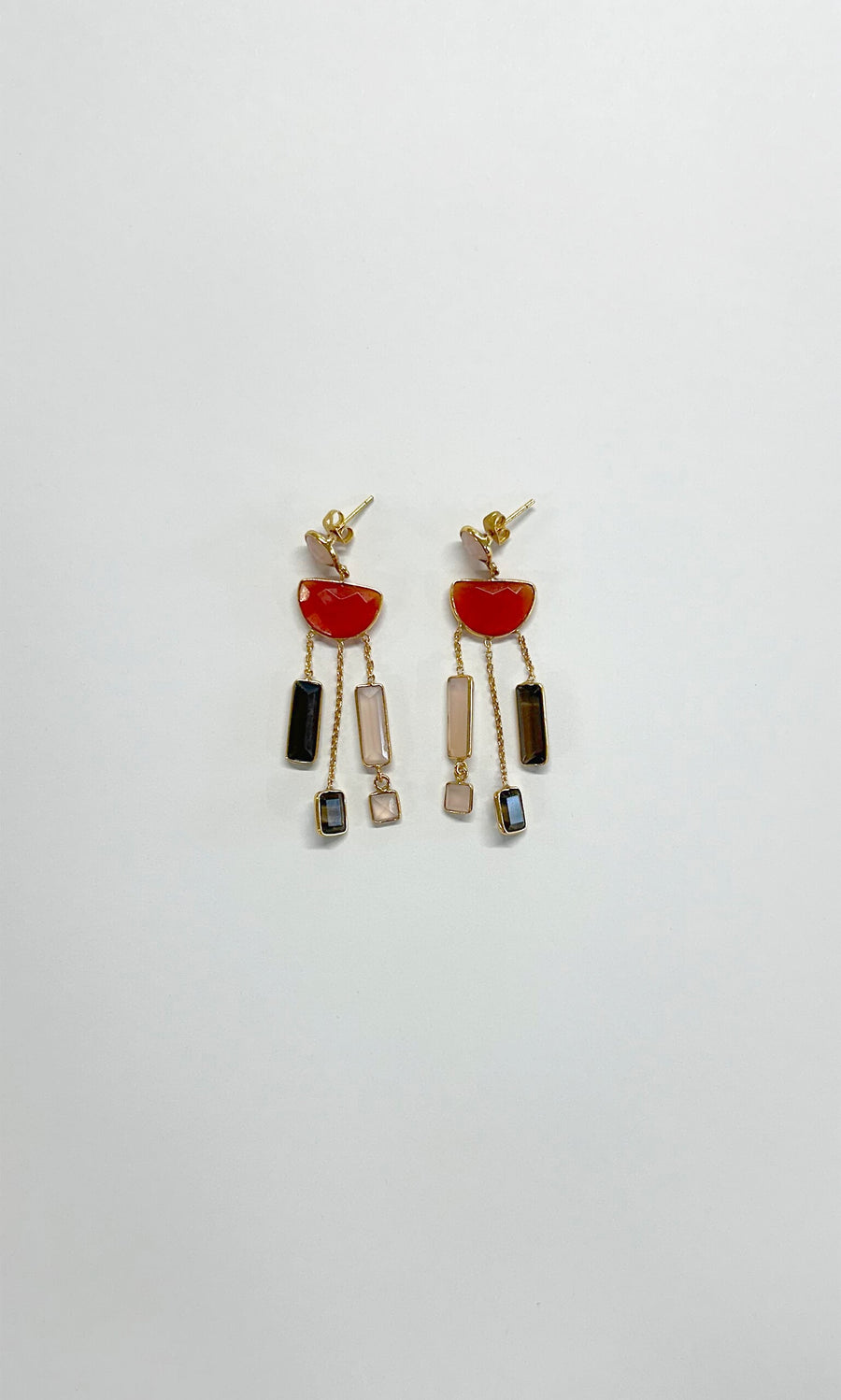 Plümo- The Skylar Earrings are gold drop earrings with red semicircles and black, pink, and blue geometric stones.