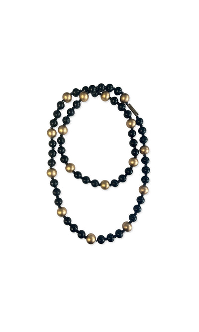 Plümo- The Suna Necklace features black wooden beads with gold accents, beautifully arranged in a loop.
