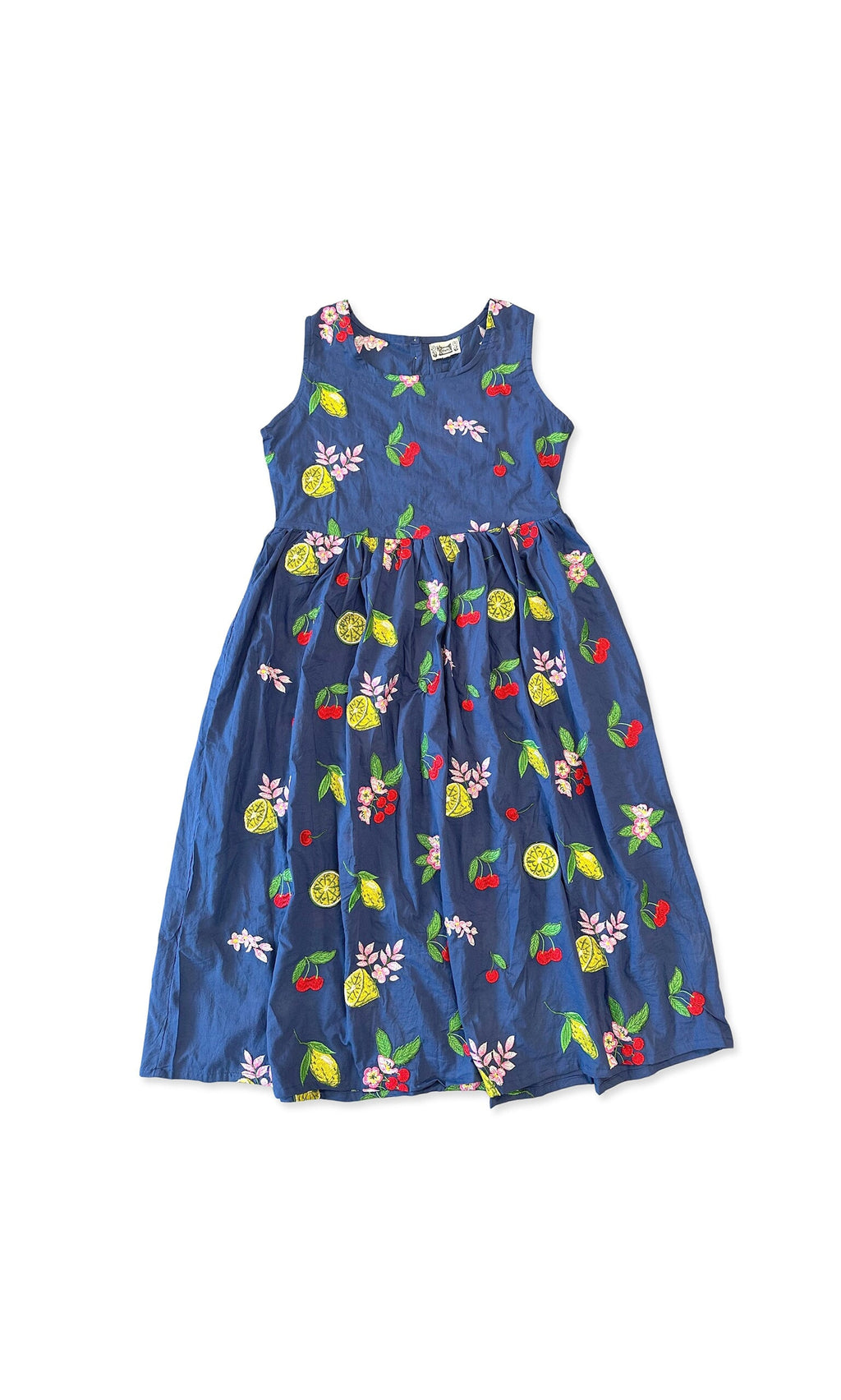 Plümo- The Talia Dress is a sleeveless navy cotton dress with vibrant fruit and floral embroidery on a white background.