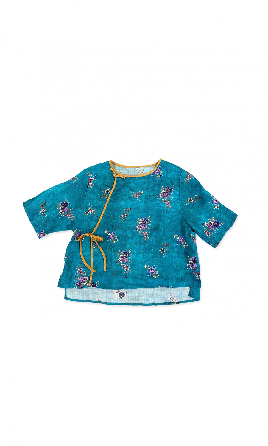 Plümo- Tomira Blouse: Blue floral wrap top with mustard trim, tie, short sleeves, and a slightly asymmetrical hem.