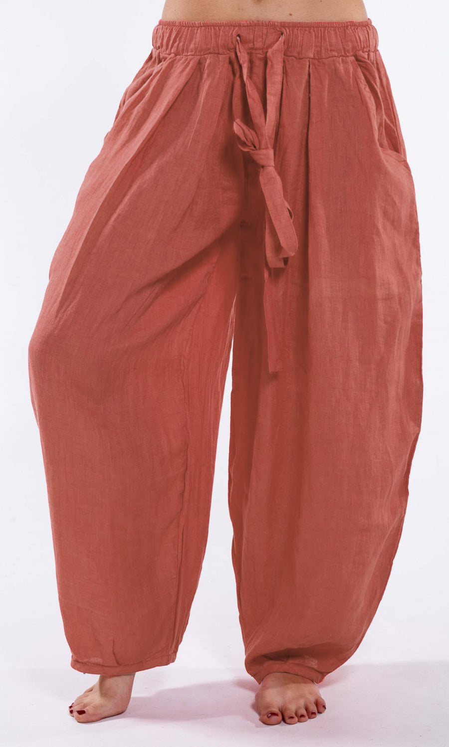 Plümo- Barefoot person in Terracotta Linen Pants with balloon legs and a matching tie belt.